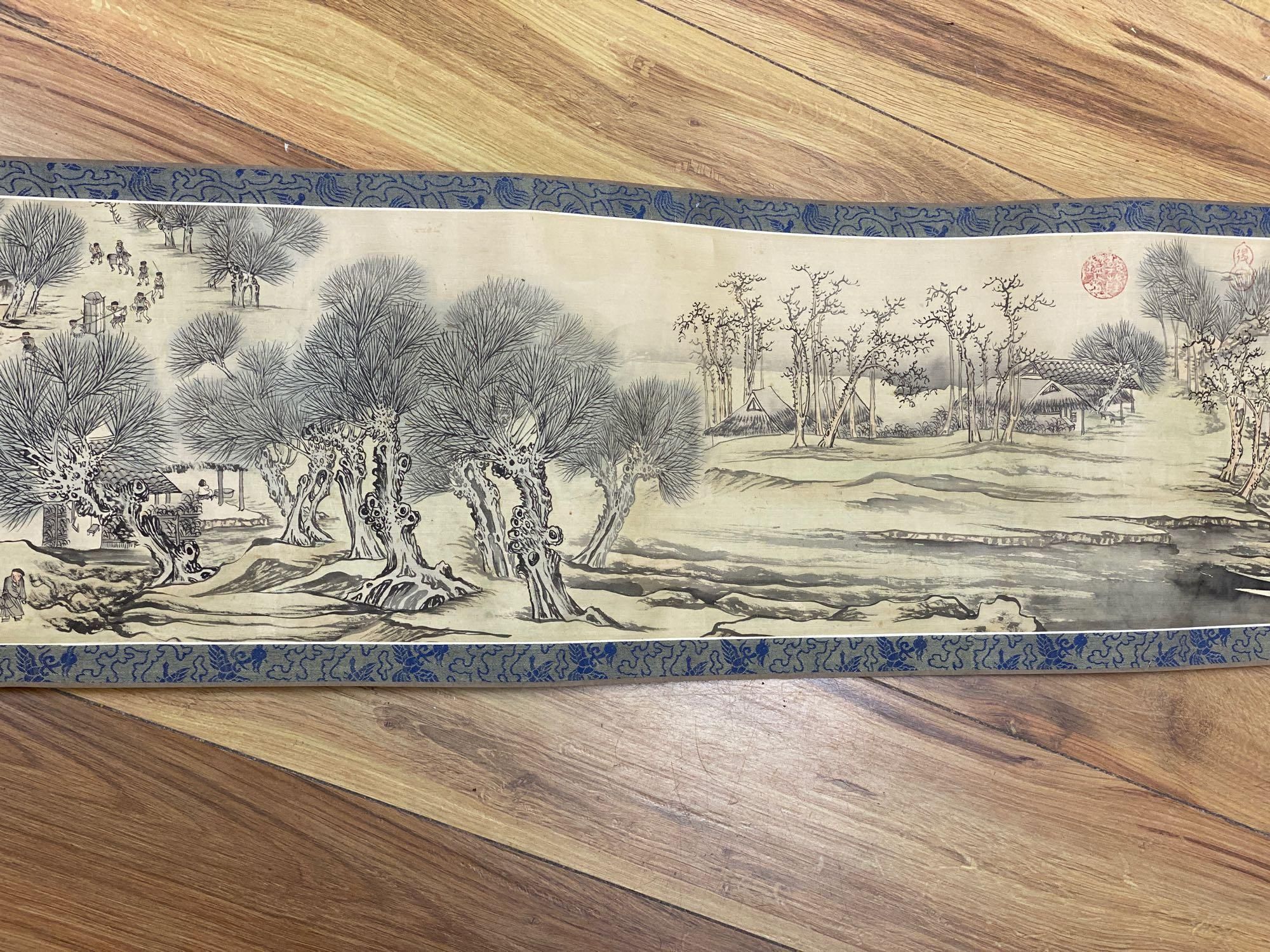 A Chinese landscape painting on silk handscroll with script, approximately 520 x 22cm